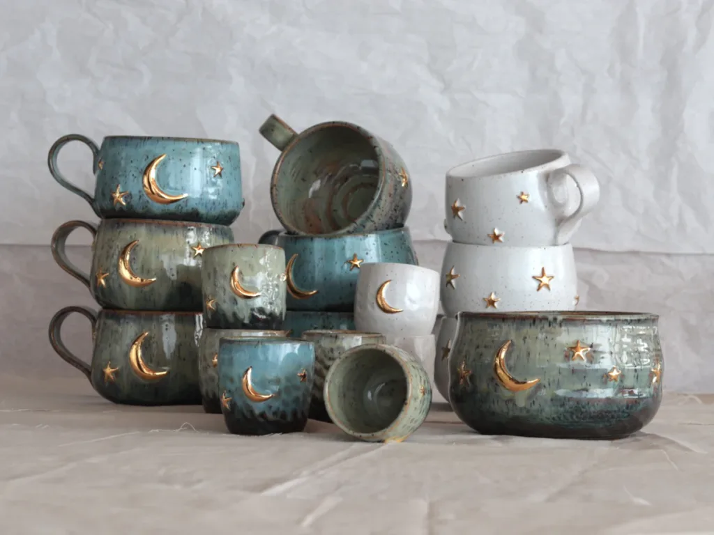 Artisan hands shaping a one-of-a-kind celestial mug, highlighting the unique textures of handcrafted pottery.