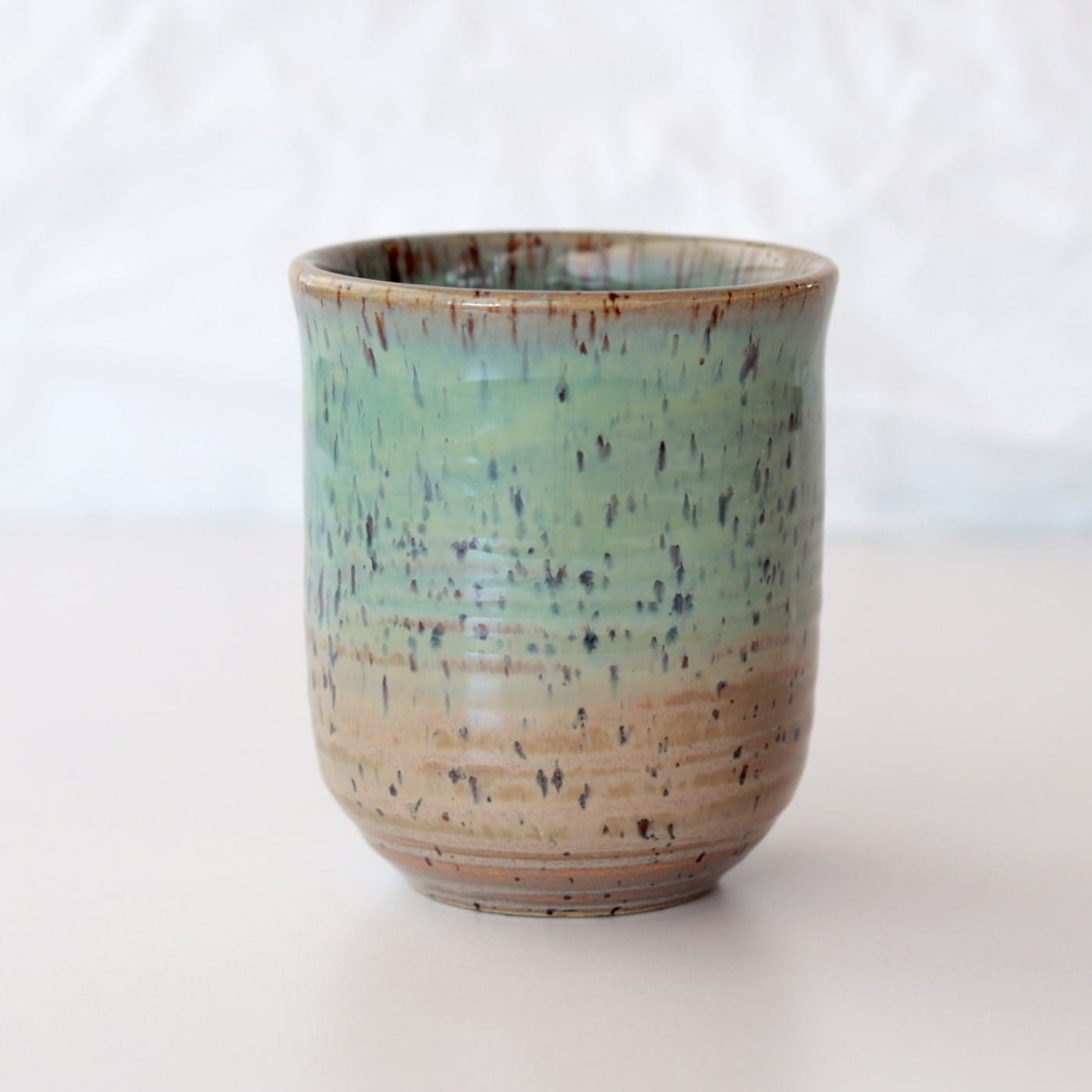 Pottery-ceramic-green-brown-mug-stonewware-no-handle-onthetable