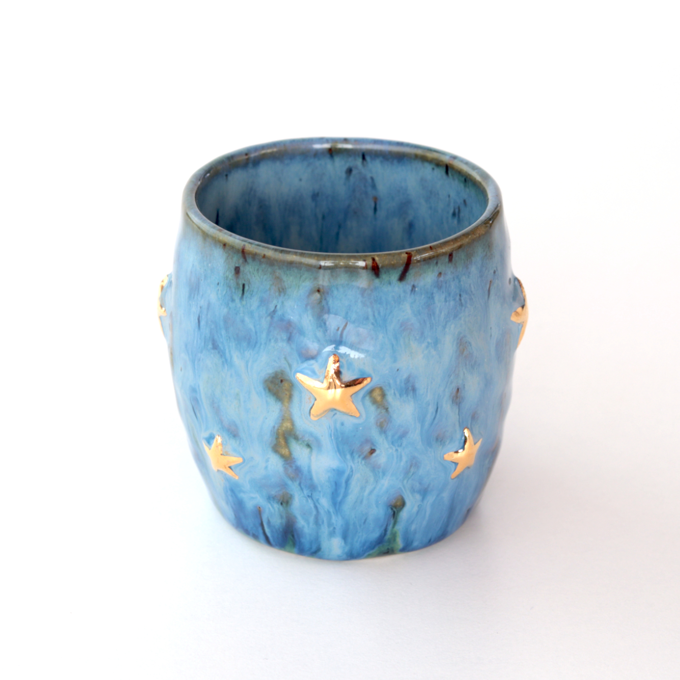 Handmade stoneware pinched blue espresso cup with gold stars – on the table Handmade stoneware pinched blue espresso cup with gold stars - on the table