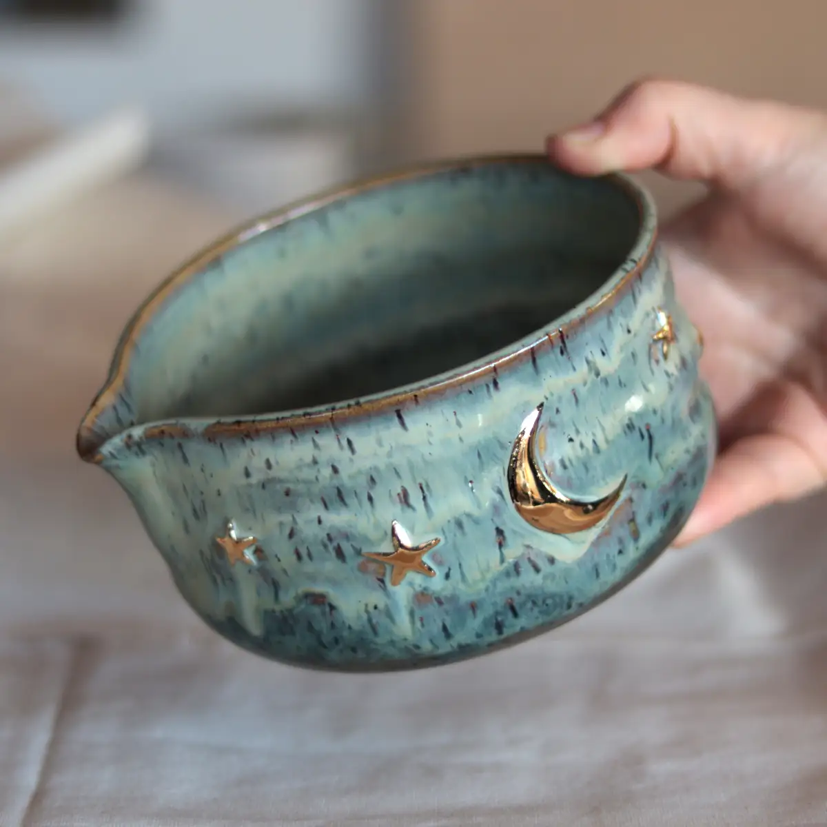 Handmade stoneware matcha bowl with gold moon and stars, teal glaze, made in Istanbul