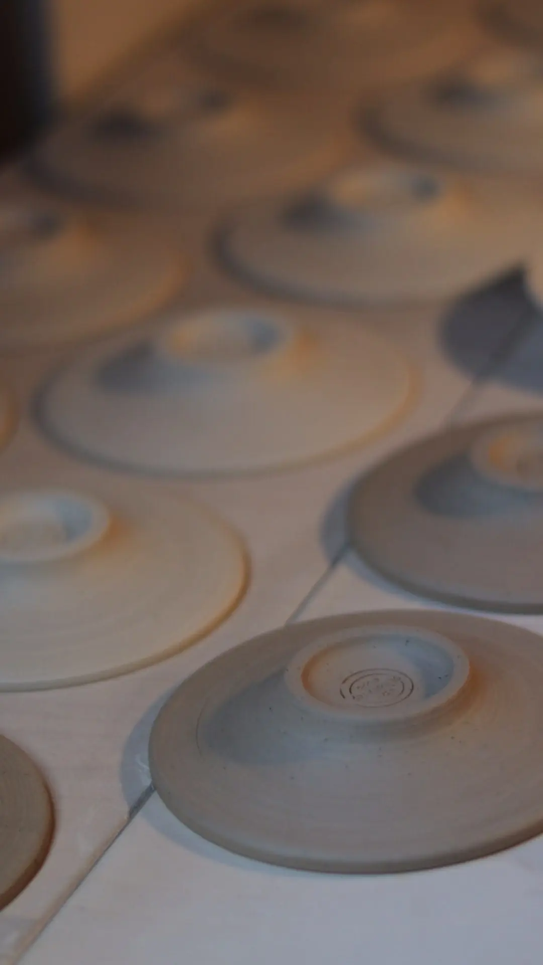 Handcrafted Stoneware Process - Hand-thrown stoneware saucers and plates drying upside down after trimming.